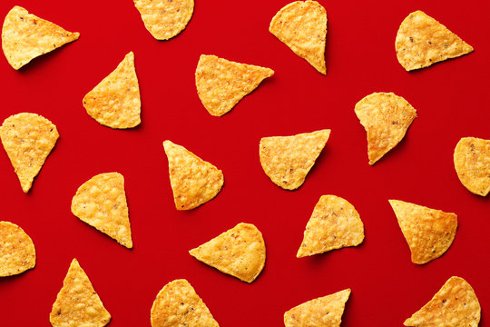 Tortilla Chips Pattern On A Red Background. Repetition Concept. Top View