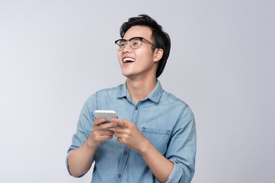 Smart casual asian man using smartphone in studio background - Powered by Adobe