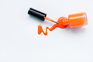 Оранжевый лак для ногтей на белом фоне с пространством для текста. Верхний вид