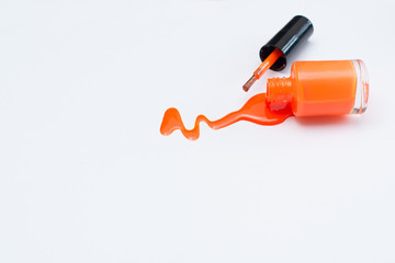 Оранжевый лак для ногтей на белом фоне с пространством для текста. Верхний вид