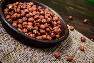 Hazelnut in bowl. Peeled nuts. Organic food on rustic wooden table with sackcloth. Top view.