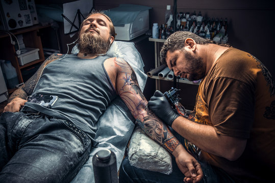 Tattoo specialist at work in tattoo studio
