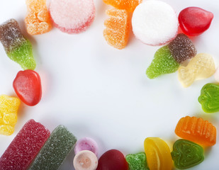 Circle made of sweets and candies of various types and flavors on white background. Copy-space.