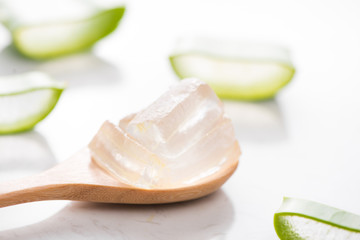 Aloe sliced and aloe vera gel on wooden spoon