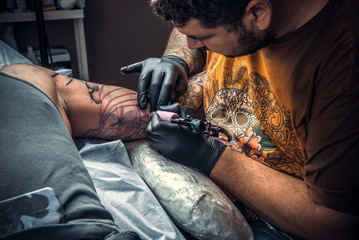 Tattooist makes tattoo pictures in studio