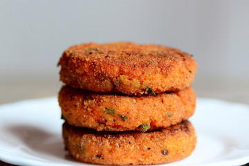 Veggie burgers on a plate. Healthy burgers prepared with carrots and herbs. Closeup