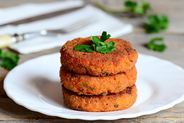 Homemade carrot burgers on a plate. Delicious carrot burgers with green onions and parsley. Closeup