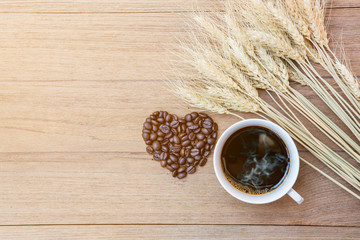 coffee cup and coffee bean heart shape on wooden table