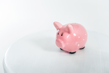 Little pink piggy bank standing on white with copy space