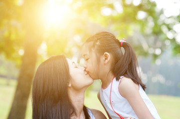 Mother and daughter kissing.