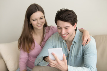 Young happy couple using tablet, making video call, hand on shoulder, online shopping, share photos, downloading apps, internet banking, booking, social networking, planning vacation