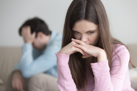 Couple not talking after a dispute, teens troubled with unwilling pregnancy. Pensive sad woman feeling guilty, upset man sitting apart. Anxious worried girl thinking over problems in relationships