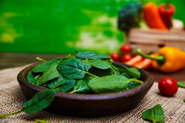 Spinach leaves in bowl. Raw fresh vegetable. Fresh natural plant leaf. Organic bio food on rustic...