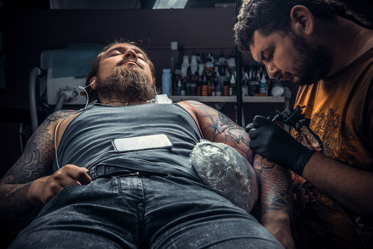 Professional tattooer makes cool tattoo in tattoo studio