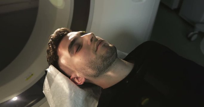 4K Close-up. Man lays in Magnetic Resonance Image device, making tomographic scanning.