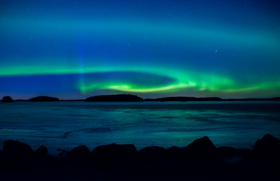 Northern lights dancing over frozen lake in spring