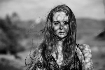 depressed young woman near the sea in a windy day. Beautiful young woman outdoors portrait near the sea black and white photo