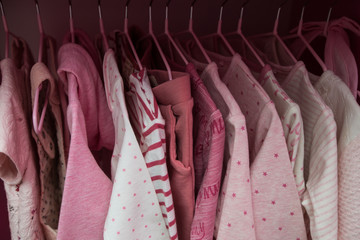 A lot of pink children's clothes on hangers. Children's wardrobe with clothes