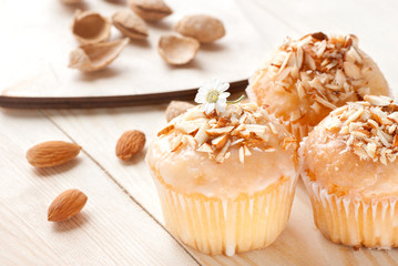 Cupcakes with almonds on a wooden table