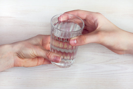 vital valuable resource/ One glass of drinking water is passed from hand to hand