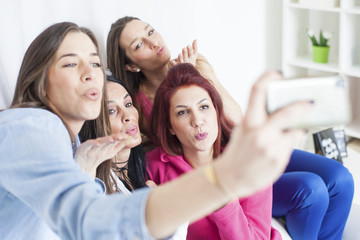 4 beautiful women having fun and taking selfie
