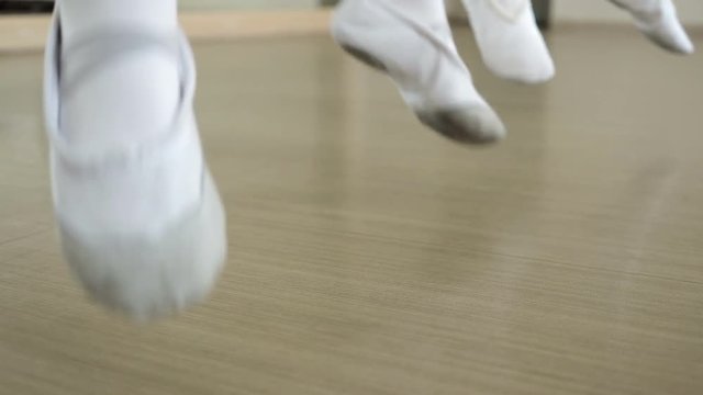 Group of ballet dancers jumping in the air. Young ballerinas jumping in training. School of ballet. Feet closeup