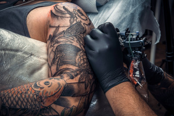 Professional tattoo artist makes cool tattoo in tattoo studio
