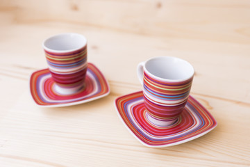 Two empty coffee mugs and saucers diagonally