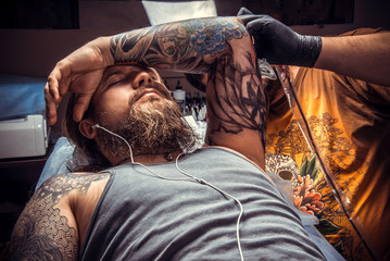 Master makes tattoo in studio