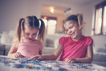 Fototapeta premium Girls playing puzzle