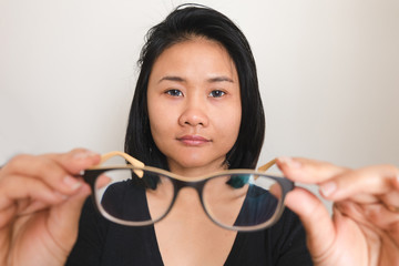 asian woman taking off glasses