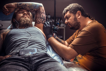 Tattooist working tattooing in studio