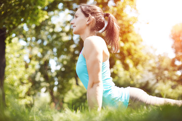 Yoga outdoor. Happy woman doing yoga exercises, meditate in the park. Yoga meditation in nature....