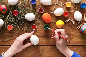 Painting colorful easter eggs background, top view on wood
