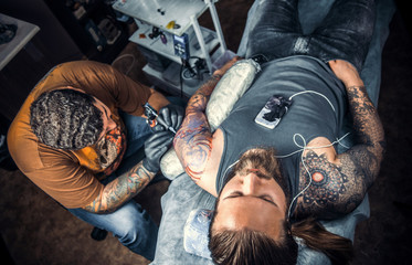 Professional tattoo artist at work in tattoo studio