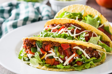 Traditional Mexican tacos with meat and vegetables on wooden background
