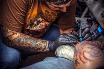 Tattoo master at work in tattoo studio