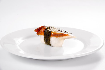 Sushi with smoked eel on a white plate on a white background.