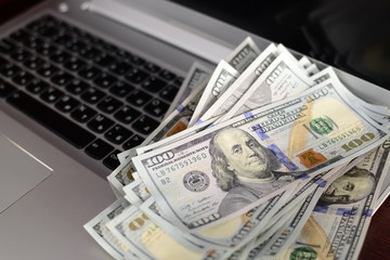Banknotes over laptop keyboard