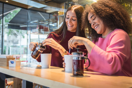 Multiracial best friends having fun at the bar drinking tea