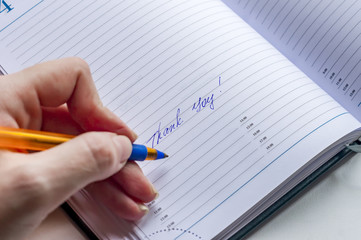 Hand writing thank you in note book
