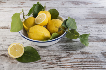 limoni in ciotola di metallo interi e tagliati sopra