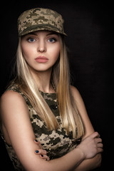 portrait of beautiful woman soldiers in military attire on black background