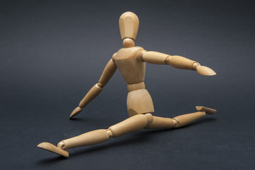 Person represented by a wooden dummy performing the splits and showing how flexible he is.