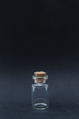 Miniature jar/Image of a one inch miniature/replica glass jar closed with a real small cork isolated on a black background. - 142465082