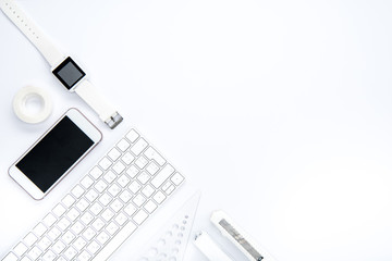 Top view of smartphone, smartwatch, keyboard and office supplies on white background