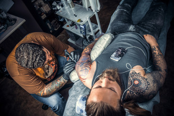 Master makes tattoo pictures in studio
