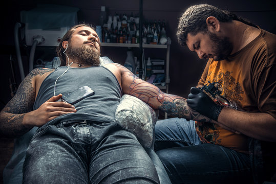 Tattoo specialist create tattoo in tattoo parlor