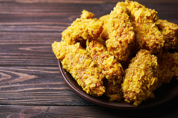 Crispy fried chicken breast on an old rustic wooden background, Close up. With a lot of copy space.