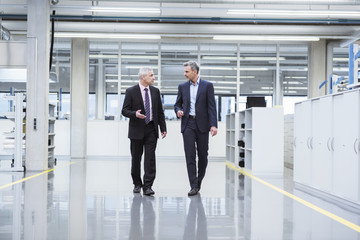 Two managers having a meeting at the shop floor of a factory